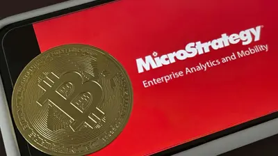 عملة «بيتكوين» وفي الخلفية شعار شركة «مايكروستراتيجي».