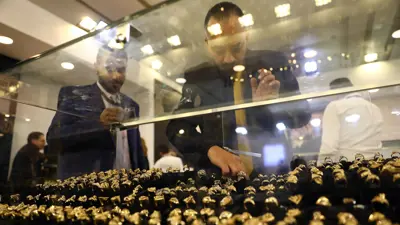 بائع يرتب المصوغات خلال المعرض الدولي للذهب والمجوهرات (نيبو) في العاصمة المصرية القاهرة يوم 20 فبراير 2022.