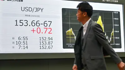 شخص يمر أمام لوحة تعرض سعر الين مقابل الدولار الأميركي وسط العاصمة اليابانية طوكيو يوم 28 أكتوبر 2024.