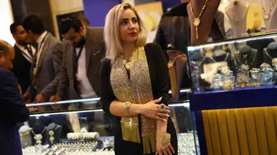 سيدة تتزين بالحلي خلال المعرض الدولي للذهب والمجوهرات «نيبو» في العاصمة المصرية القاهرة يوم 20 فبراير 2022.