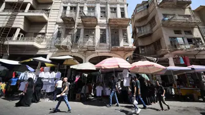 يمرون عبر أحد الأسواق وسط العاصمة العراقية بغداد يوم 10 سبتمبر 2024.