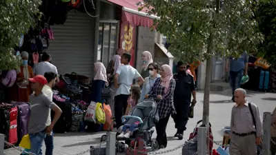 فلسطينيون أمام محلات تجارية في مدينة رام الله بالضفة الغربية – 14 مايو 2020.