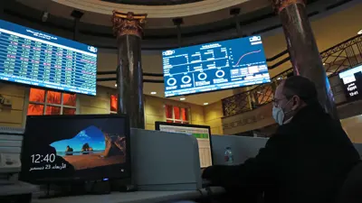متداول يتابع أسعار الأسهم على شاشة البورصة المصرية في العاصمة القاهرة يوم 23 ديسمبر 2020.
