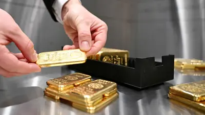 يمسك سبيكة ذهبية في دار «برو أوروم» بمدينة ميونيخ الألمانية يوم 10 يناير 2025