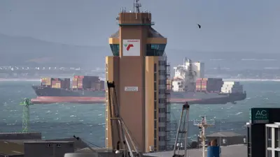 ترسو سفينة في ميناء كيب تاون، خلف برج مراقبة الميناء التابع لشركة ترانسنت، في كيب تاون، جنوب إفريقيا، يوم 27 يوليو 2021.