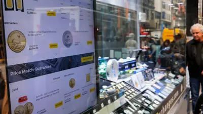 يتابع المعروضات على واجهة محل للذهب في بورصة السبائك وسط حي الماس بمدينة نيويورك الأميركية يوم 4 ديسمبر 2023.