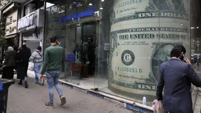 أشخاص يمرون بجوار مكتب صرافة في العاصمة المصرية القاهرة، في 21 مارس 2022.