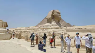 سياح يقفون بالقرب من تمثال أبو الهول في الجيزة، مصر يوم 21 يوليو 2024.