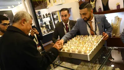 شخص يعرض قلادة خلال المعرض الدولي للذهب والمجوهرات «نيبو» في العاصمة المصرية القاهرة، يوم 20 فبراير 2022.