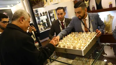شخص يعرض قلادة خلال المعرض الدولي للذهب والمجوهرات «نيبو» في العاصمة المصرية القاهرة، 20 فبراير 2022.
