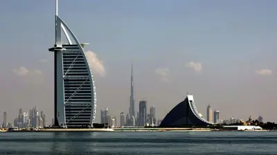 صورة تظهر ثلاثاً من أبرز الأيقونات المعمارية في دبي، فندق برج العرب (يسار)، وفندق جميرة (يمين)، وبرج خليفة (وسط)، على طول ساحل دبي، الإمارات العربية المتحدة، في 21 ديسمبر 2009.