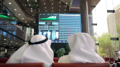 شخصان يتابعان شاشات تحركات الأسهم في بورصة الكويت يوم 2 مارس 2022.