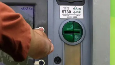شخص يستخدم صرافاً آلياً للبنك الأهلي السعودي في العاصمة الرياض يوم 27 مارس 2023.