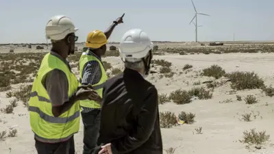 مسؤولون في شركة الكهرباء الموريتانية خلال جولة في حقل توربينات في نواكشوط، في 21 مارس 2023.