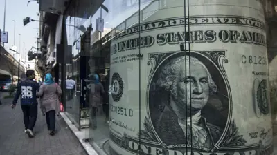 يمران بجوار مكتب صرافة في العاصمة المصرية القاهرة يوم 3 نوفمبر 2016.