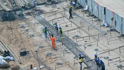 عمال خلال أداء مهامهم بموقع بناء على جزيرة المرجان في الإمارات يوم 20 فبراير 2025.