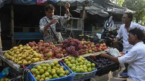 بائع يزن الفاكهة لأحد الزبائن عند عربة في الشارع بمدينة كلكتا في الهند، في 29 أغسطس 2026.