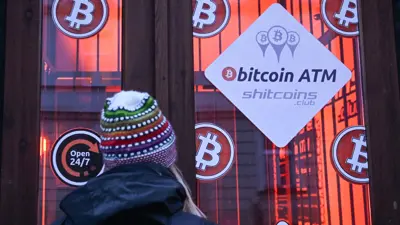 تتحقق من أسعار «بيتكوين» عبر نافذة جهاز صراف آلي للعملة المشفرة في مدينة جيشوف البولندية يوم 16 ديسمبر 2024. 