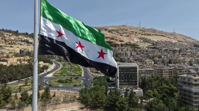  العلم السوري يرفرف فوق سارية بحديقة تشرين في العاصمة دمشق