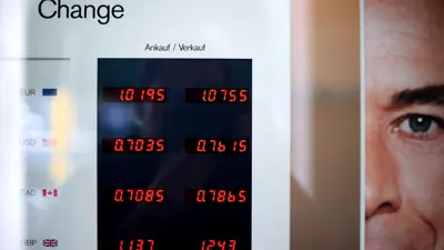 لوحة تعرض أسعار عملات اليورو والدولار الأميركي والدولار الكندي والجنيه الإسترليني مع الفرنك السويسري في مدينة برن السويسرية يوم 10 أغسطس 2011.