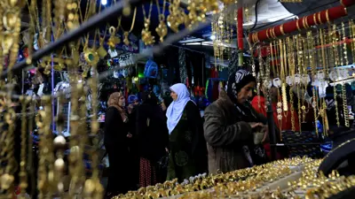 سيدات أمام متاجر لبيع المشغولات الذهبية في مدينة القامشلي السورية، يوم 2 مايو 2018.