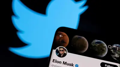 تظهر صورة إيلون ماسك على هاتف ذكي موضوعاً فوق شعارات «تويتر» المطبوعة في هذه الصورة التوضيحية التي تم التقاطها في 28 أبريل 2022.