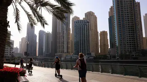 وافدون في نزهة على ضفاف قناة القوارب في منطقة «دبي مارينا» يوم 3 مارس 2026