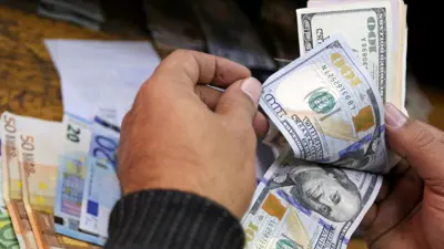 يعد أوراقاً من الدولار الأميركي واليورو بمكتب صرافة في العاصمة المصرية القاهرة يوم 27 ديسمبر 2016.