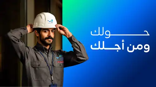 مهندس يعرض شعار «السعودية للطاقة» في مقر التحكم بشبكة للكهرباء
