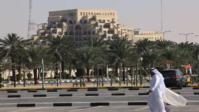 رجل يسير في موقف سيارات بالقرب من منتجع سياحي بجوار جزيرة المرجان في رأس الخيمة، الإمارات العربية المتحدة، يوم 26 يناير 2022.