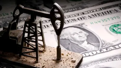 مجسم مضخة موضوع على أوراق نقدية من الدولار الأميركي.