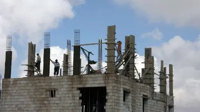 عمال في موقع بناء مبنى سكني في عمان، الأردن.