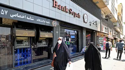 تمران أمام فرع مغلق لبنك سبه في العاصمة الإيرانية طهران يوم 20 يوليو 2021.