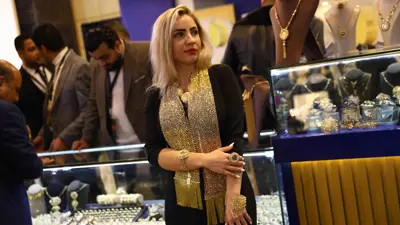 سيدة تتزين بالحلي خلال المعرض الدولي للذهب والمجوهرات «نيبو» في العاصمة المصرية القاهرة يوم 20 فبراير 2022.