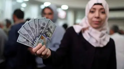 موظفة فلسطينية تتسلم راتبها في غزة. 