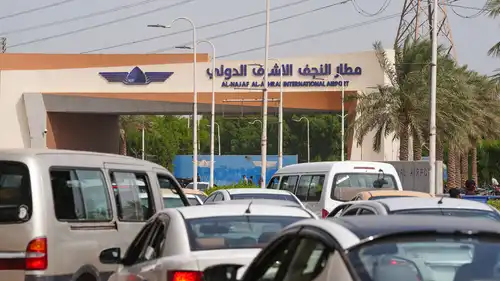 تمر المركبات عبر بوابة الدخول إلى مطار النجف الأشرف الدولي في مدينة النجف بوسط العراق، في 4 أكتوبر 2026.