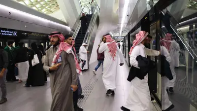 سعوديون في محطة مترو مركز الملك عبد الله المالي (KAFD) في العاصمة السعودية الرياض في 1 ديسمبر 2024.