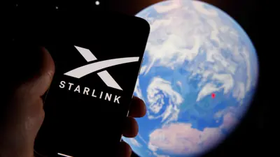  شعار Starlink على جهاز محمول مع رسم توضيحي لكوكب الأرض  