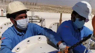 عاملان في شركة «السعودية للكهرباء» يباشران صيانة أحد المفاتيح الغازية في المنطقة الشرقية، السعودية