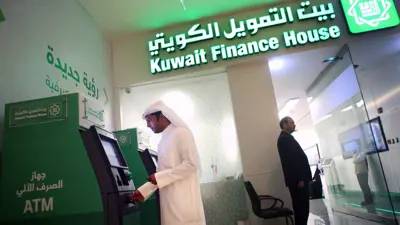  عميل يسحب نقودا من ماكينة صرف آلي خارج فرع بيت التمويل الكويتي داخل مجمع الأفنيوز، الكويت، 19 نوفمبر 2014