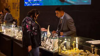 سيدة تشاهد مشغولات ذهبية خلال المعرض الدولي للذهب والمجوهرات «نيبو» في العاصمة المصرية القاهرة،2022