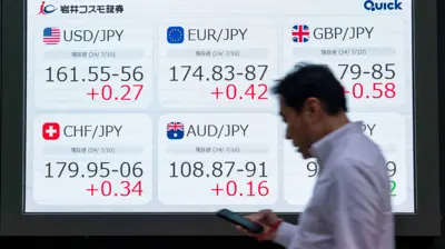 يمر أمام لوحة إلكترونية تعرض سعر صرف الين مقابل العملات الرئيسية في العاصمة اليابانية طوكيو ـ  10 يوليو 2024