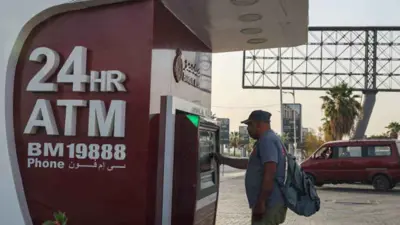 شخص يستخدم ماكينة صرف آلي تابعة لبنك مصر في العاصمة القاهرة يوم 8 يونيو 2024