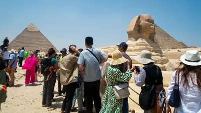 سياح بالقرب من تمثال أبو الهول أثناء زيارتهم للأهرامات المصرية في مدينة الجيزة يوم 30 إبريل 2024.