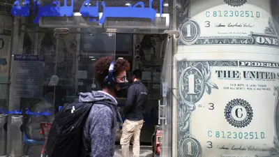يمر بجوار مكتب صرافة في العاصمة المصرية القاهرة يوم 21 مارس 2022.