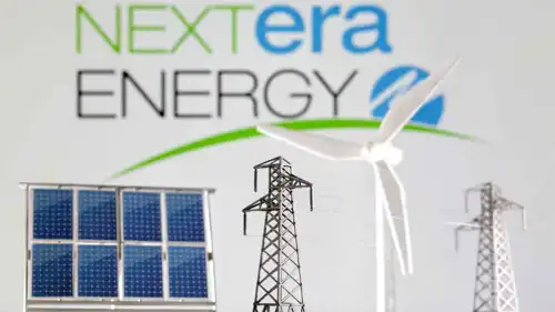 نماذج مصغرة لطاحونة هوائية ولوحة شمسية وعمود كهربائي أمام شعار شركة نيكستيرا إنرجي، في هذه الصورة الملتقطة في 17 يناير 2023