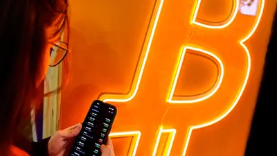 زائرة لمعرض الهواتف الذكية في برشلونة تتابع أسعار البتكوين - 10 مارس 2023
